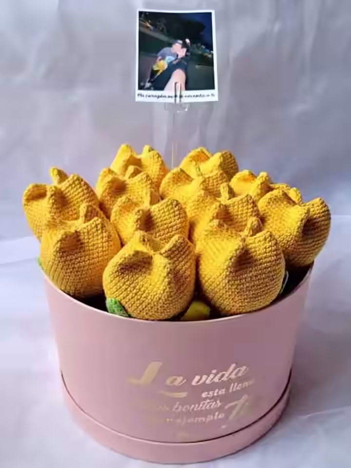 Florero con forma de cilindro con un hermoso ramo de tulipanes tejidos a crochet de diversos colores